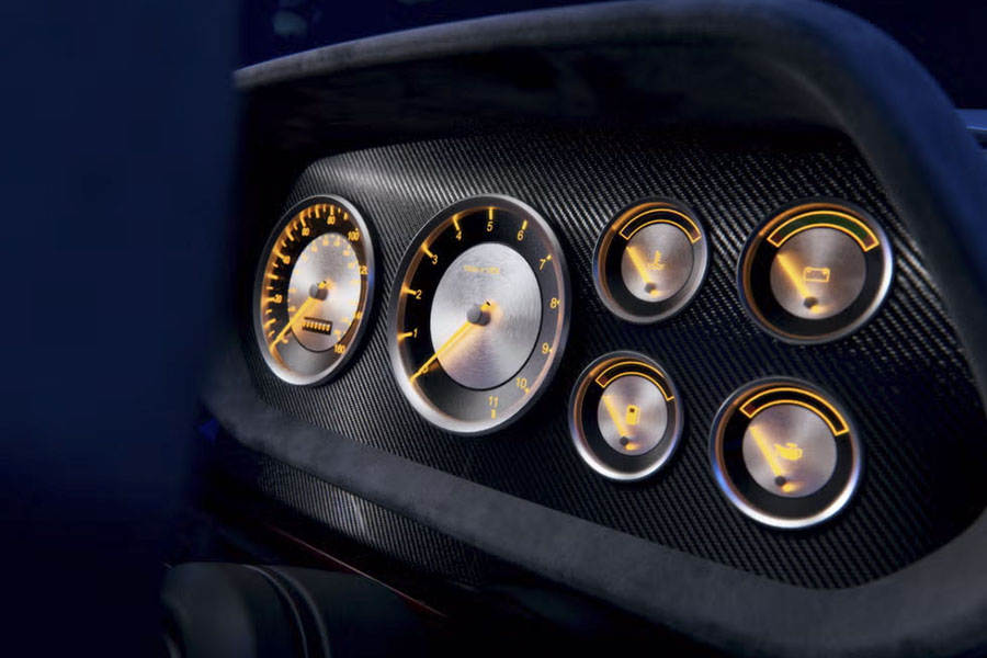 Minimalistisch und doch luxuriös: Die goldenen Akzente auf der Instrumententafel sind ein eleganter Tribut an die Vergangenheit, während das Carbon-Finish die Technik von morgen repräsentiert. 