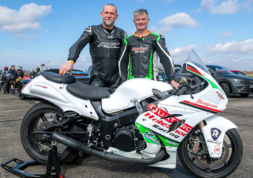 Le calme avant la tempête : Frost et Milbourn posent avec leur Hayabusa turbo comme s’il s’agissait d’une balade dominicale. En réalité, la bête à leurs côtés est un enfer mécanique sur roues – fait main, suralimenté, avide de records. 800 chevaux n’attendent que le prochain décollage.