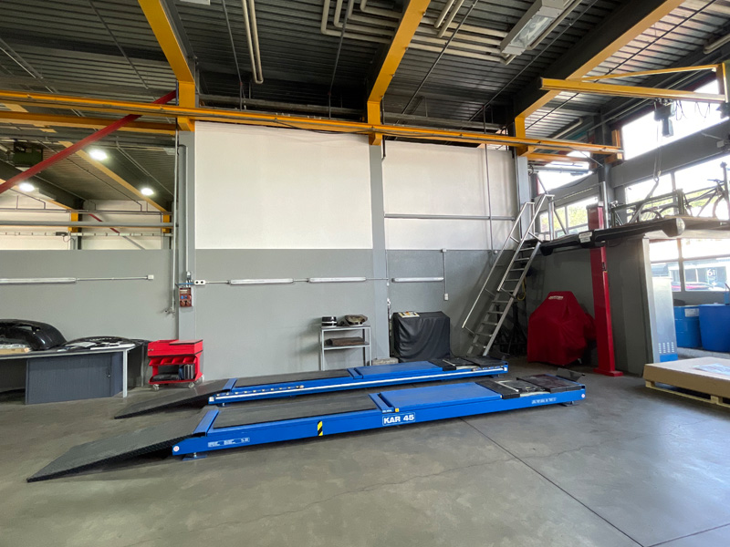 Poste de travail pour les experts: pont élévateur spécial avec installation de calibrage des essieux.