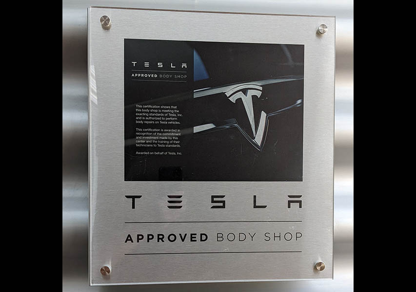 Das gläserne Zertifikat macht es deutlich: Hier dürfen Tesla-Elektroautos offiziell repariert werden. 