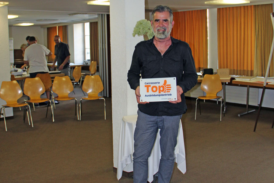 Hat allen Grund zum Strahlen: Joos Pinggera mit der Plakette, die ihn zum «Top-Ausbildungsbetrieb» adelt.