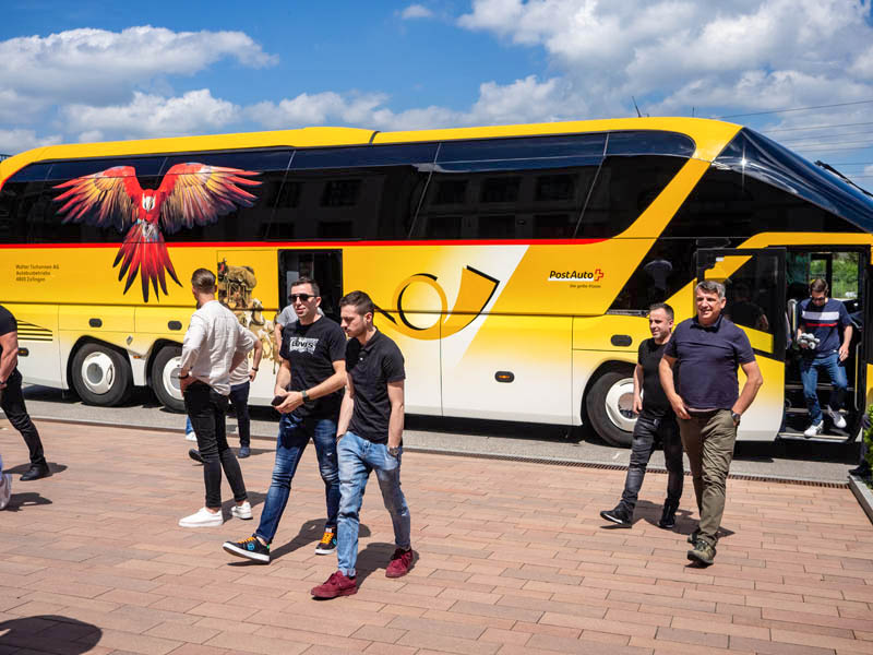 Die Gäste kommen im gelben Postauto an, das mit Glasurit-Papagei «Ruedi» verziert ist.