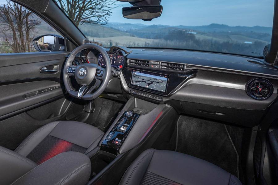 Cockpit mit Charme: Das leicht zum Fahrer geneigte Display, das unten abgeflachte Lenkrad und die angenehm dunkle Materialmischung machen den Junior Ibrida zu einem Platz, an dem man sich wohl fühlt. 