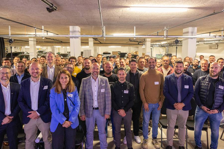 Photo finale des participants de Repanet Suisse : assureurs, carrossiers, spécialistes de la peinture – unis sous la lumière des néons par un même objectif : la précision avec conviction.