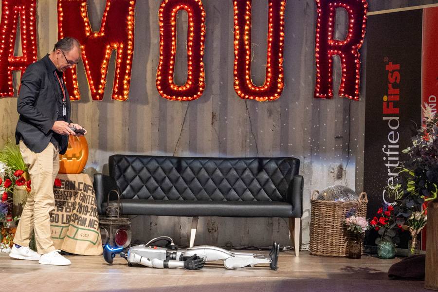 Per Klick in die Zukunft: René Vogel hat die Fernbedienung in der Hand – und «Henrietta» liegt scheinbar erschöpft da. Sekunden später beginnt das Metallwesen sich zu regen – ein leises Raunen im Saal, gefolgt von staunenden Blicken.