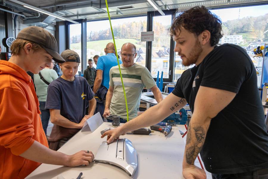 Marcus Lombriser (à gauche), apprenti tôlier-carrossier chez « Auto Mathis » à St-Moritz, est venu avec son frère et son père. Au stand de Lenny Granata, il s’informe sur la matière enseignée.