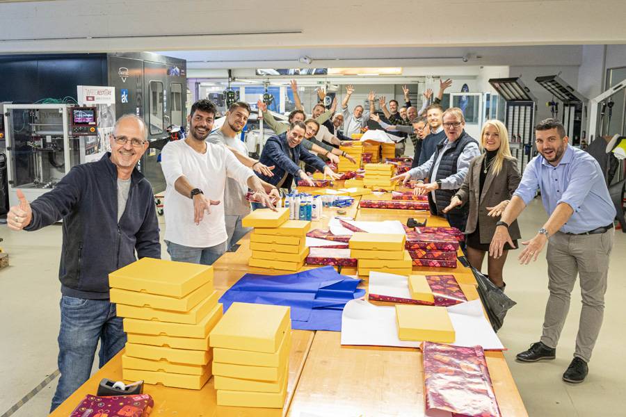 Die Päckli-Produktion läuft wie am Fliessband: Das Team von Axalta – André Koch legt los, als hätte jemand das Schulungscenter kurzerhand zur Geschenkfabrik erklärt. Unter anderem mit dabei: alle Helferinnen und Helfer, die den Abend zu diesem kollektiven Kraftakt machen.