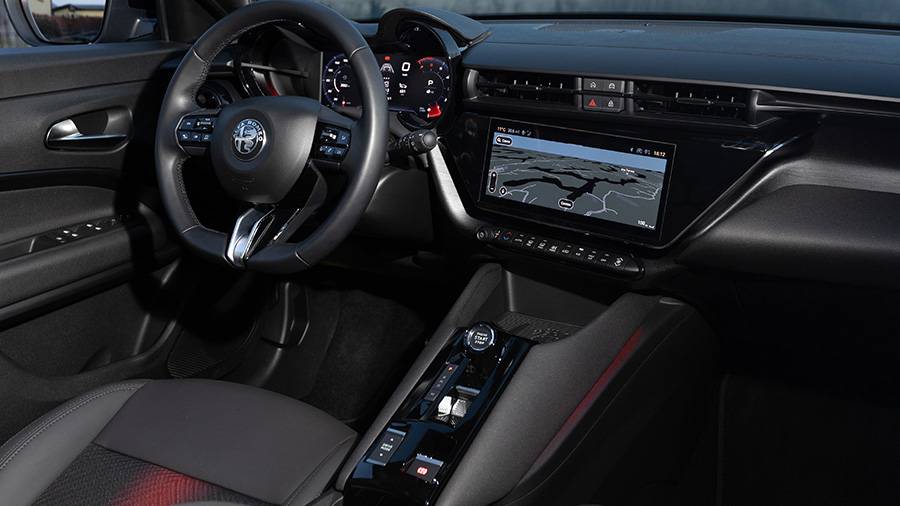 À bord, le pragmatisme italien domine : ambiance sombre, commandes claires et un siège massant pour le conducteur — tandis que le passager règle sa vie à la main.