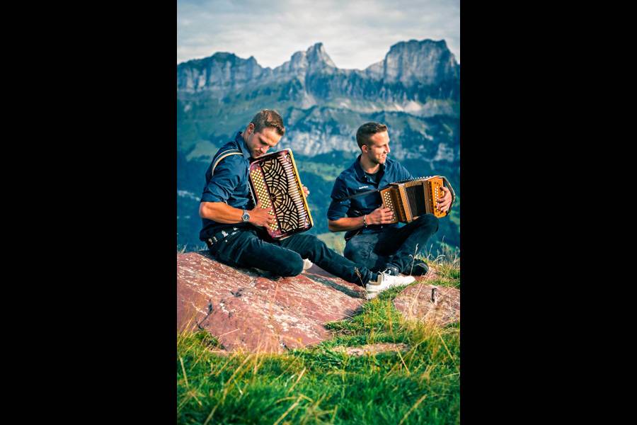 Oben im Schwyzer Berglicht: Simon (links) und sein Zwillingsbruder Cyrill vertieft in ihre Örgeliklänge – zwei junge Musiker, die zwischen Felsen, Gras und Fernsicht ihren ureigenen Sound finden.