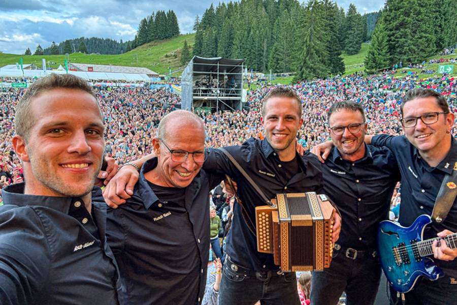 Les Rusch-Büeblä en plein air, entourés de leurs musiciens accompagnateurs – un open air comme on en rêve. Une grande scène, beaucoup d’entrain, et ce mélange unique de musique folklorique, de dialecte et d’identité schwyzoise – le public est captivé dès la première mesure.