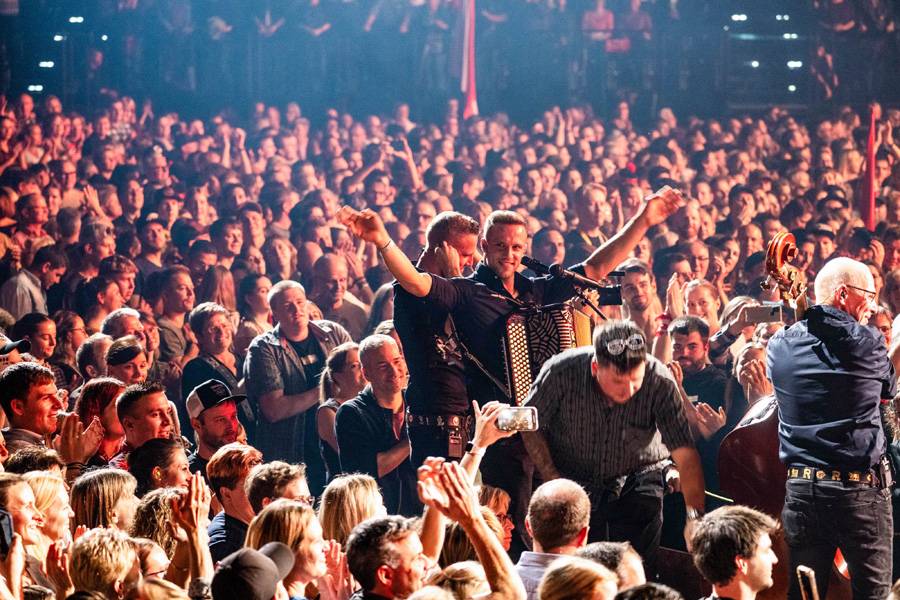 Hallenstadion en liesse : les jumeaux Simon et Cyrill Rusch fêtent leur prestation avec leur père Roger – au milieu de centaines de fans enthousiastes qui vibrent au rythme de chaque note des Rusch-Büeblä.