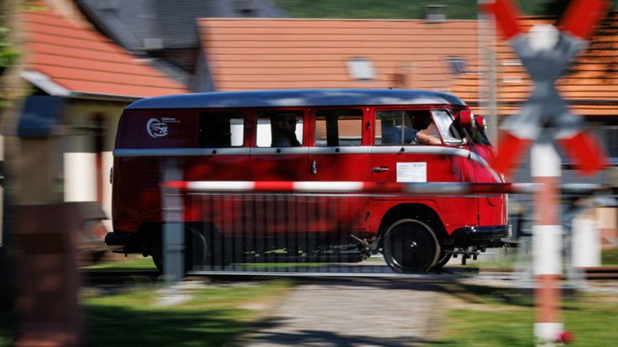 Der Klv 20 rauscht durch den Bahnübergang – ein T1, der statt Asphalt Schienen frisst. Unter der vertrauten Bulli-Carrosserie arbeitet ein 28-PS-Industriemotor, während Stahlräder und Schienenfahrgestell das Tempo in ein trockenes, gleichmässiges Rumpeln übersetzen.