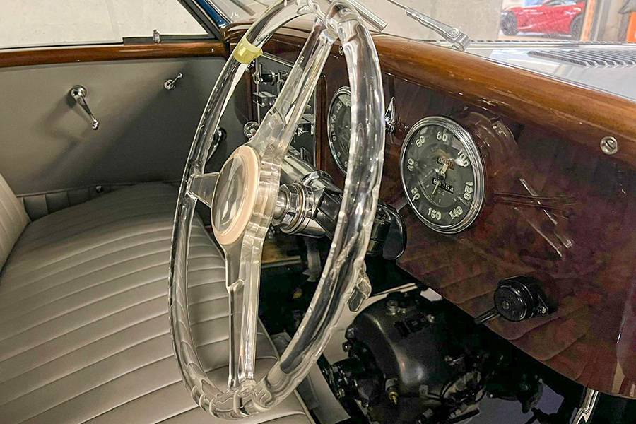 Blick ins Cockpit: Holz und klare Instrumente. Kein Bildschirm weit und breit, dafür ein Lenkrad wie ein Schmuckstück und ein Arbeitsplatz, der das Fahren noch als Handwerk versteht.