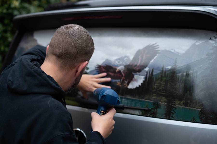 Montage d’un lettrage en film micro-perforé sur le hayon d’une voiture : impact visuel maximal de l’extérieur, visibilité préservée depuis l’intérieur – un design fonctionnel, exécuté avec une précision irréprochable.