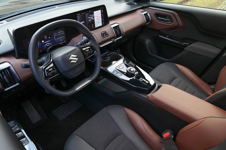 À bord, Suzuki surprend par sa modernité : grands écrans, lignes nettes, ambiance bicolore. Beaucoup de rangements, une sensation robuste au toucher — un cockpit qui dit plutôt « on roule » que « strictement fonctionnel ».