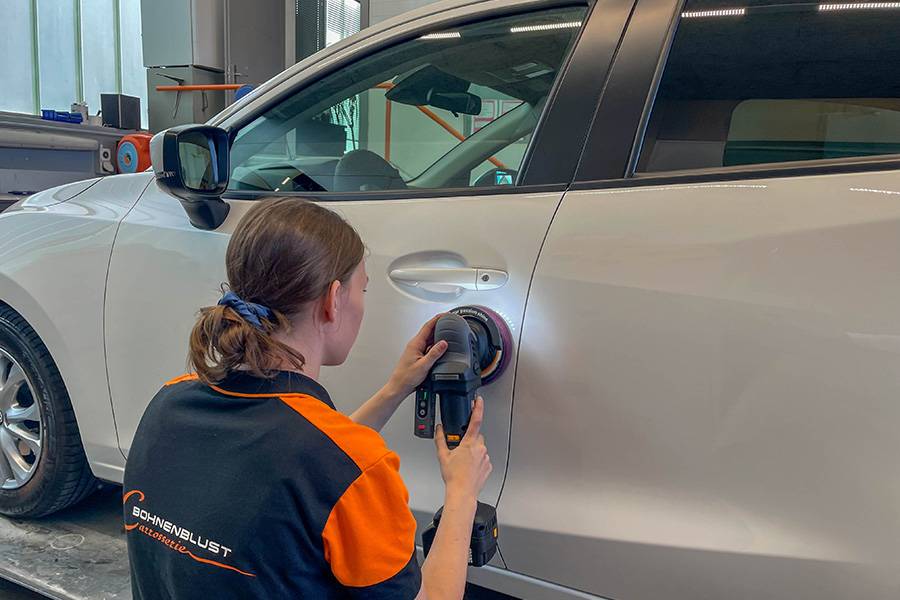 Glanzarbeit mit modernster Technik: Manuela Lüdi zelebriert präzises Polieren an der Seitenflanke, bis der Lack wieder so ruhig daliegt wie ein frisch gezogener Spiegel. Feinarbeit, die man sieht – und fühlt.