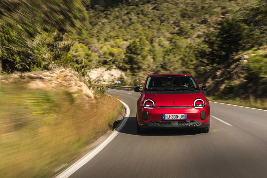 Der neue Renault Twingo E-Tech electric auf kurviger Strecke auf Ibiza: kompakt, wendig und mit jenem freundlichen Gesicht, das sofort an den Geist des Originals erinnert.