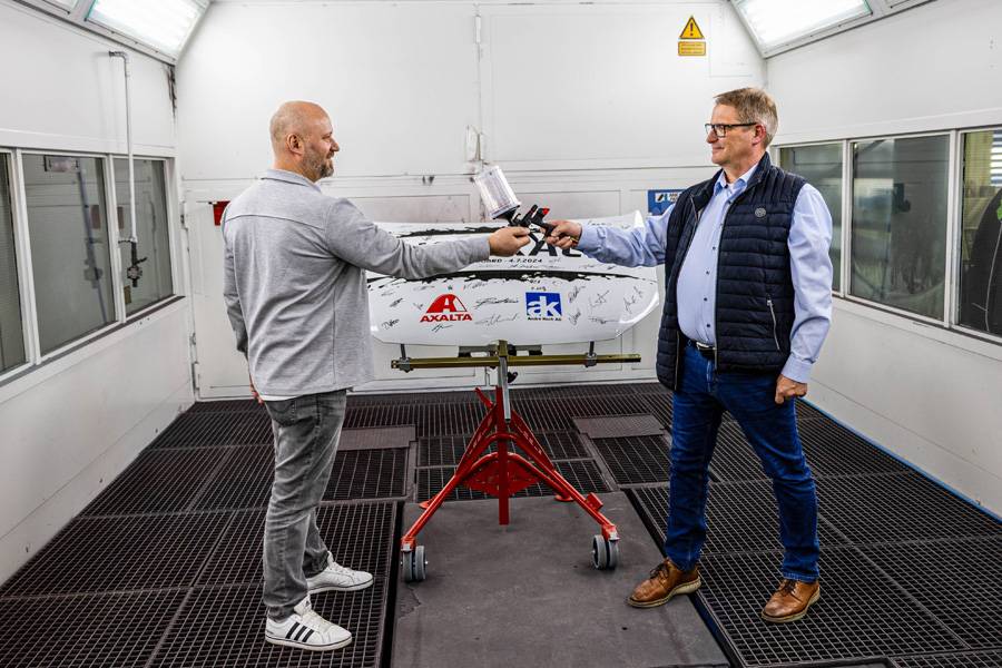 Symbolischer Moment in der Lackierkabine: Clint Kaufmann (links) übernimmt von Volker Wistorf – praxisnah und mit Blick nach vorn.