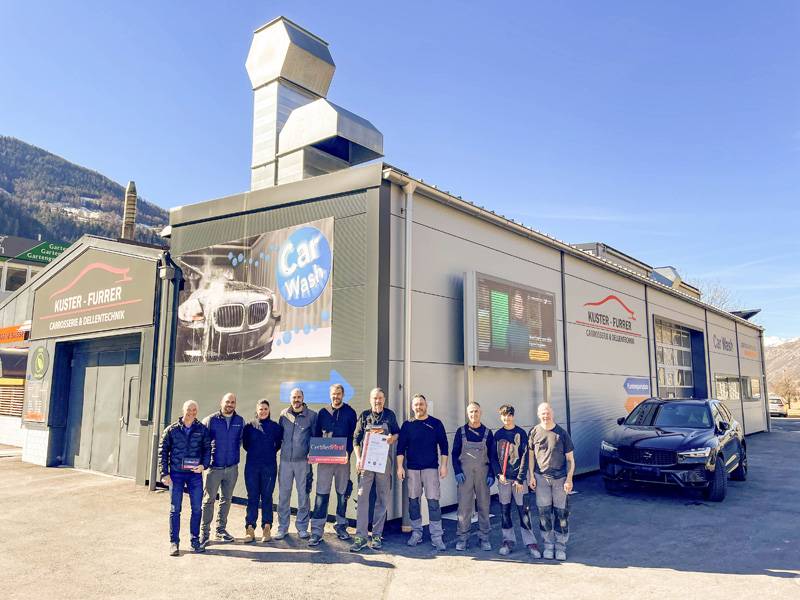 Das Team der Kuster & Furrer AG vor dem Betrieb in Gampel: Joel Furrer hält die «Certified First»-Tafel, Andreas Kuster präsentiert das Zertifikat zur Aufnahme ins Netzwerk.