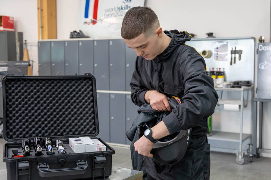 Davide Manieri ertastet im Helm die Stelle, die leicht am Kopf drückt. Nach dem genauen Bestimmen der Problemzone wird sie erwärmt und passend gemacht. 