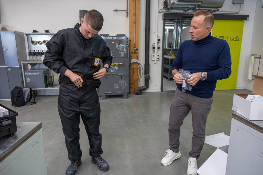 Davide Manieri passt den Gurt an, an dem die Frischlufteinheit mit Luftschläuchen befestigt wird. Auch hier zählt der korrekte Sitz bis ins Detail.