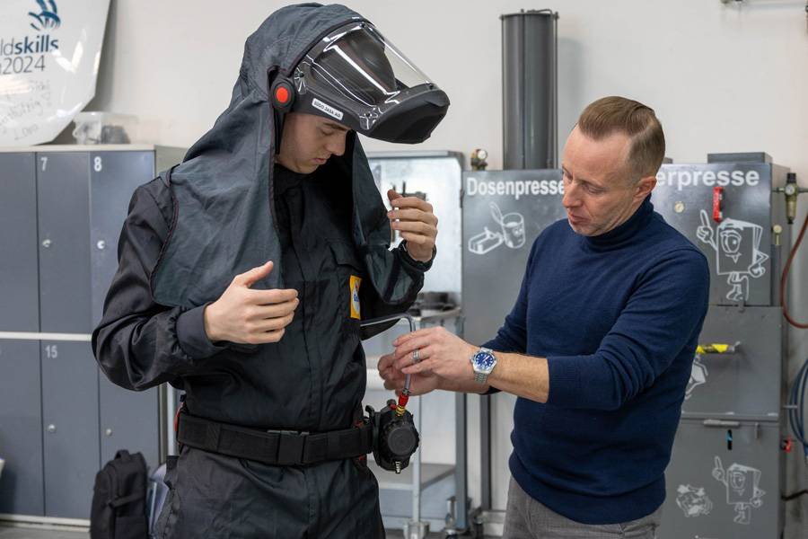 Voilà: Helm, Frischlufteinheit und Luftschlauch sind montiert. Andreas Stocker prüft, ob alles richtig sitzt und sauber abgestimmt ist.