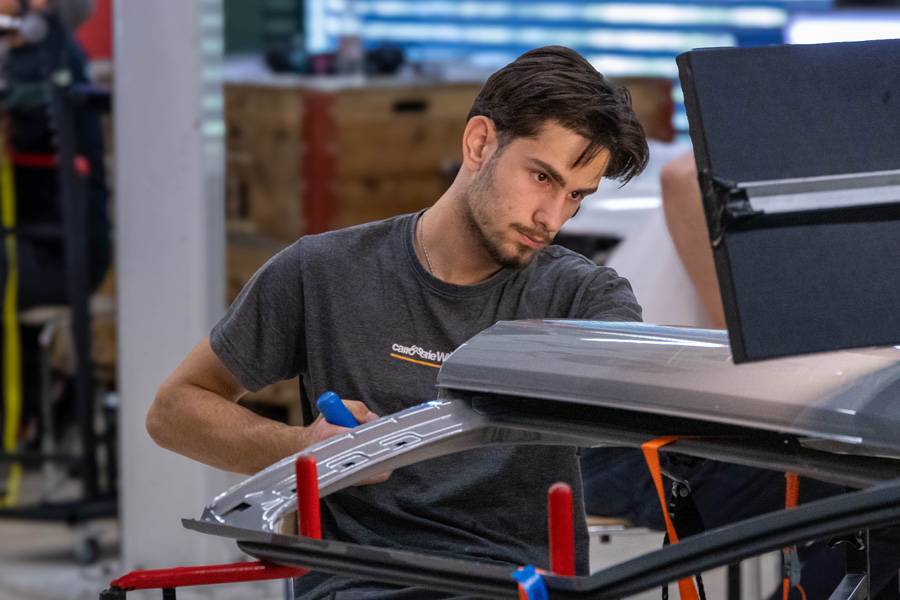 Aziz Alijovski von Carrosserie Wüest AG bei der konzentrierten Arbeit am Bauteil. Am Vormittag stand die klassische Drücktechnik im Fokus – Millimeterarbeit mit Spezialwerkzeug.