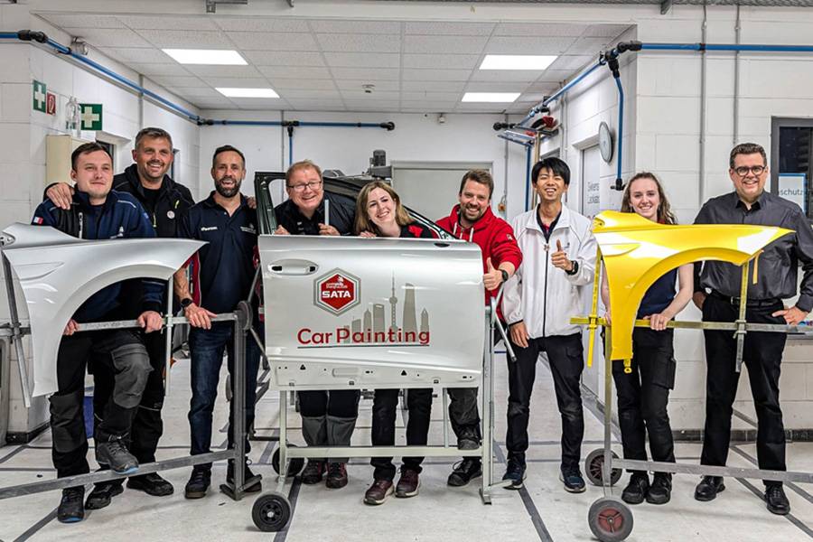 Internationales Spalier vor lackierten Prüfstücken: Die Experten (v. l.) aus Frankreich, Kroatien, dem United Kingdom, Deutschland, Kanada, der Schweiz, Japan und Norwegen. Rechts Joern Stoever, Verantwortlicher der Sata Challenge.