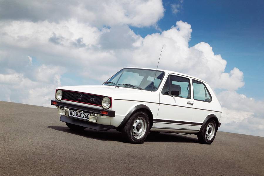 En 1976, la première GTI entrait en scène comme une promesse compacte : 110 ch, peu de poids, liseré rouge entourant la calandre, sièges à carreaux et pommeau de vitesse façon balle de golf. Une voiture pour se rendre au travail, qui cherchait soudain le col du Klausen sur le chemin du retour.