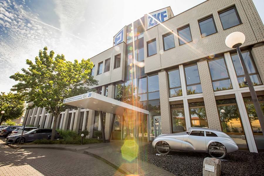Sonnenklarer Auftritt am Deutschen Kompetenzzentrum: «Eurogarant» zeigt, wie traditionelles Handwerk und moderne Fahrzeugtechnik unter einem Dach zusammenfinden – mit einem silbernen Klassiker als stilvollem Empfangskomitee.