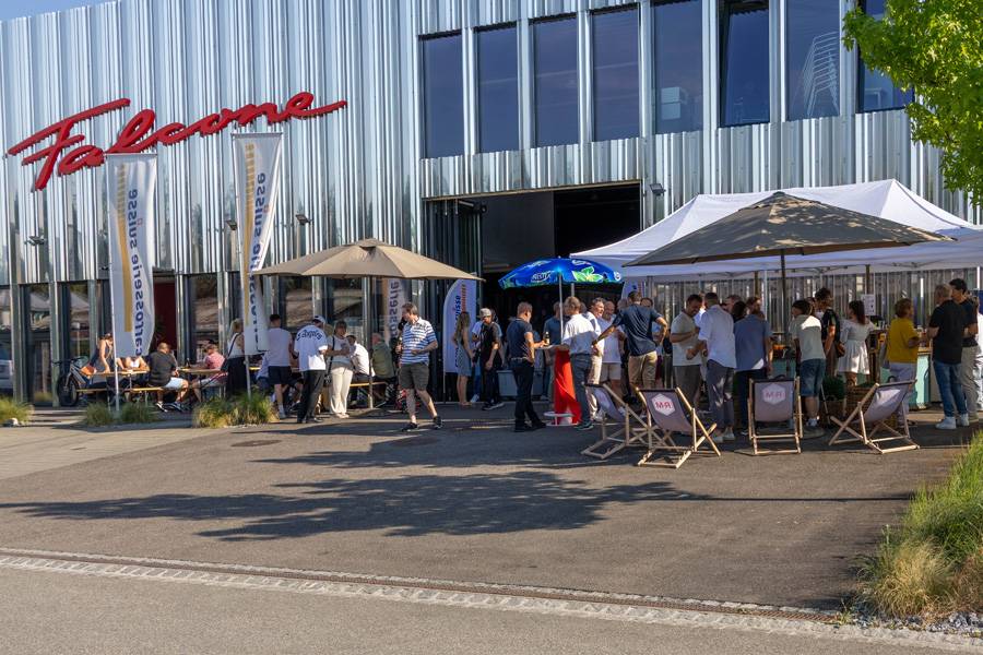 Sommerabend mit Werkstattflair: Vor der Carrosserie Falcone geniessen die Gäste den Lehrabschlussanlass bei bestem Wetter, guter Stimmung und einem Apéro mit Baranschluss.
