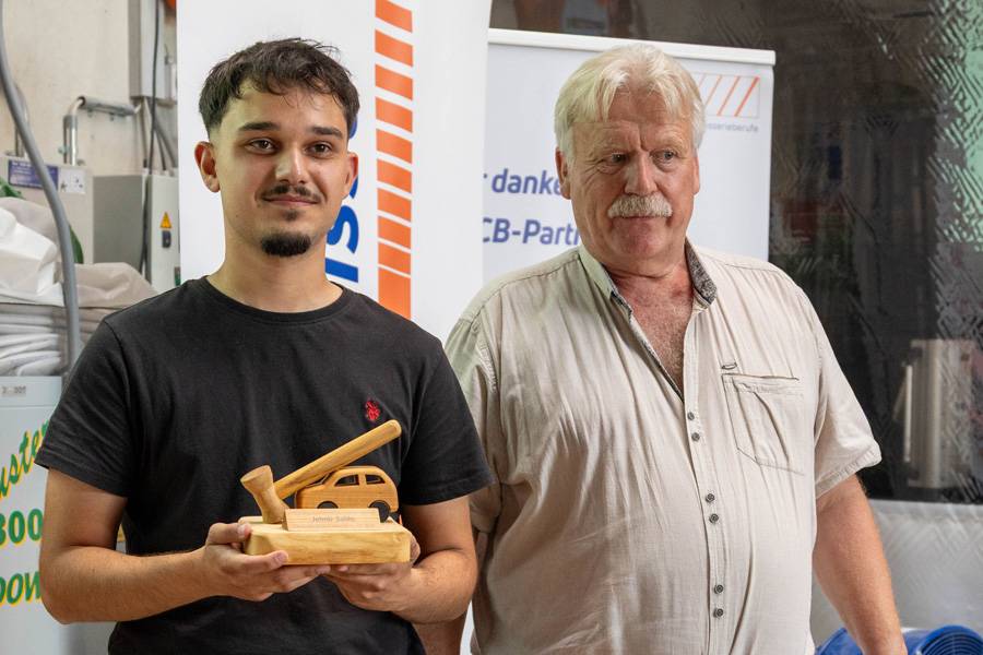 Allein an der Spitze: Jetmir Salihi nahm als einziger – und damit bester – Carrosseriereparateur seine kleine Holzstatuette entgegen. Ein Preis mit Symbolkraft und sauberem Handwerk im Miniaturformat.