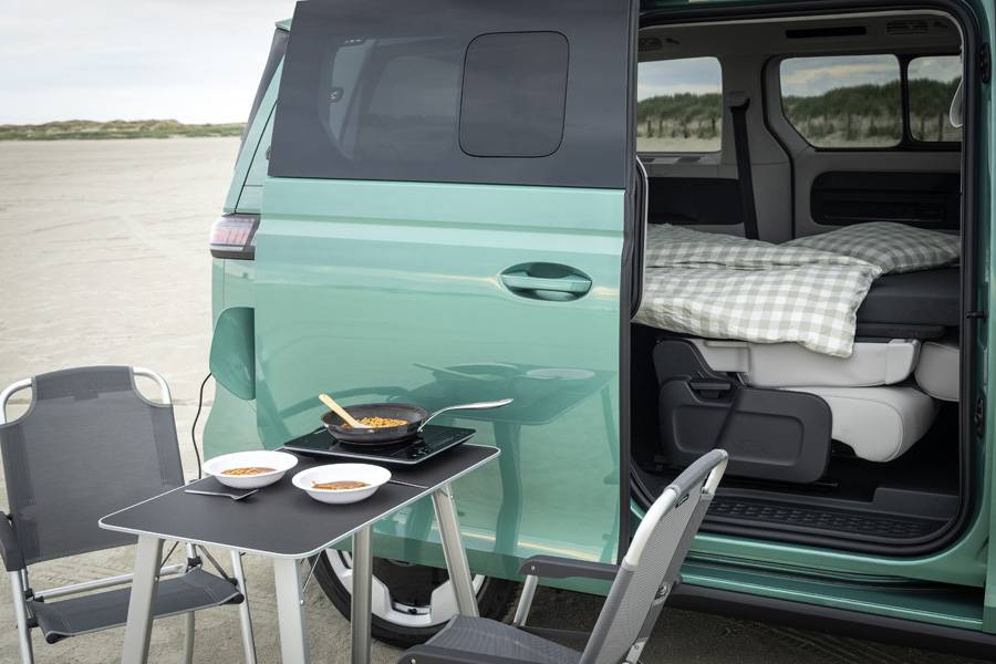 La surface de couchage sur mesure transforme l’arrière du bus électrique en espace nuit pour deux personnes: simple, fonctionnel, et avec vue comprise.