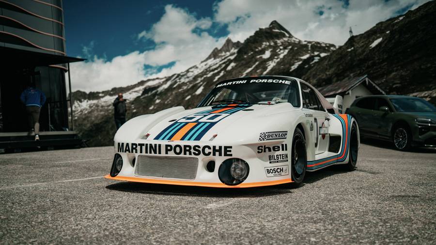Der Porsche 935/77 in Martini-Lackierung wirkt auf dem Grimselpass fast selbstverständlich. Ein Rennwagen, der aussieht, als hätte ihn jemand mit Lineal, Wahnsinn und sehr viel Abtrieb gezeichnet.