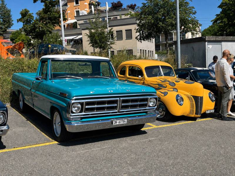 Encore une dose d’Amérique: le Ford 100 Pickup classique et le Ford Custom Hot Rod jaune en livrée flamboyante attendent côte à côte les compliments du public