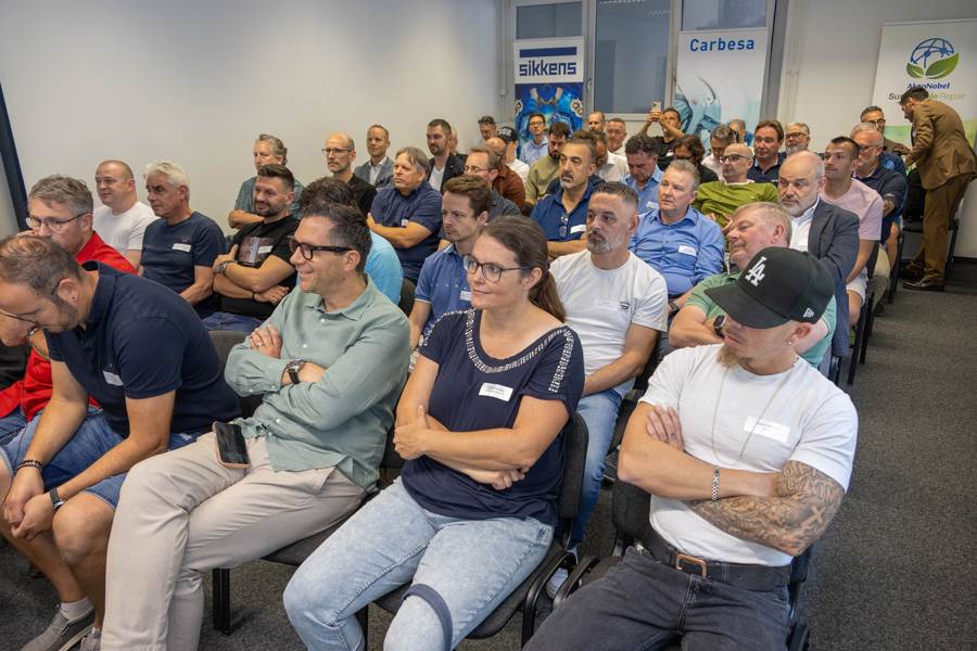 Dans la salle de théorie, les invités prennent place et attendent les exposés avec intérêt – le calme règne encore avant que le CO₂, l’efficience et la technique de  peinture ne prennent les commandes.