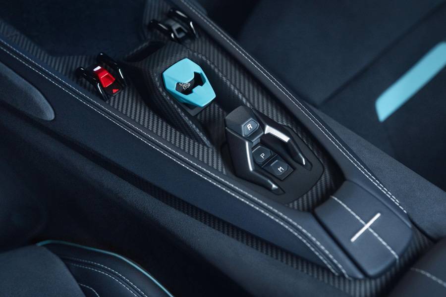 **Bild 08:** 
Carbon, präzise Nähte und ein farblich abgestimmter Startknopf: Auch die Mittelkonsole trägt den Massanzug bis ins letzte Detail.
