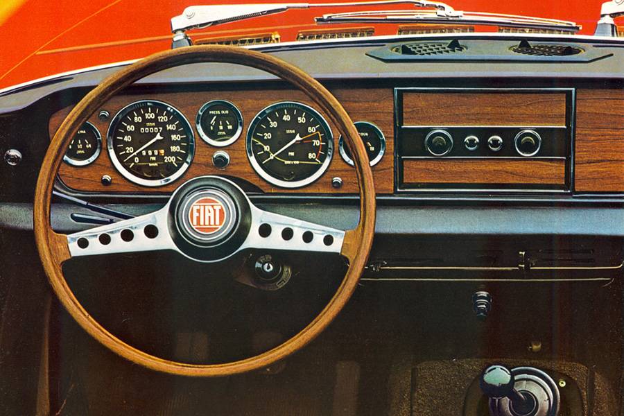 Boiseries, cadrans ronds et volant à branches ajourées: l’habitacle du Fiat 124 Sport Spider marie l’élégance italienne à une sobriété résolument sportive.