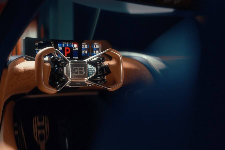 Presque trop délicat pour une voiture de course: le volant associe structures métalliques apparentes, cuir et emblème Bugatti en position centrale.