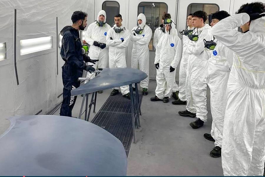 Apprendre là où l’on travaillera demain: dans la cabine de peinture, des jeunes du centre de formation professionnelle AFGP Bonsignori découvrent la réalité du métier. Le cursus développé avec la Capelloni Academy associe techniques de peinture et travail de la tôle.