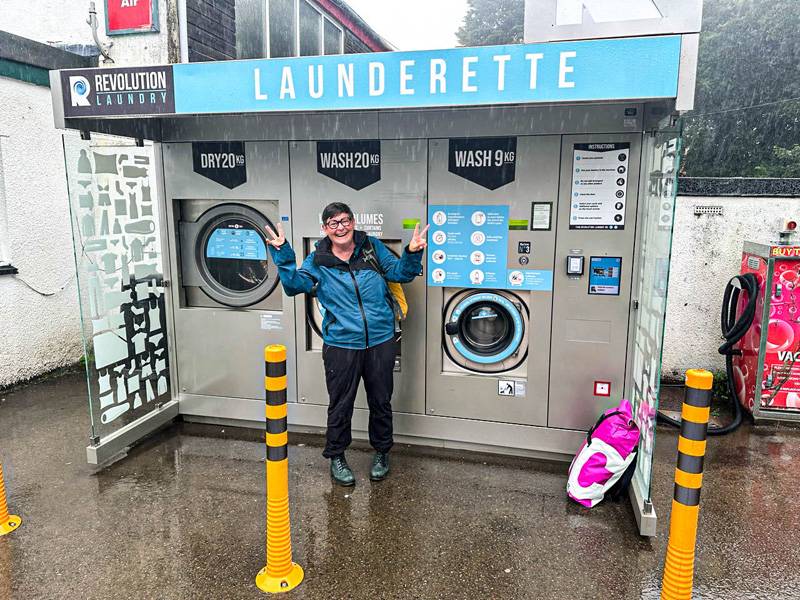 Jour de lessive, avec supplément météo : dans le sud de l’Angleterre, Marie-Louise Anderegg affronte une pluie battante à la laverie, juste à côté de la station-service.