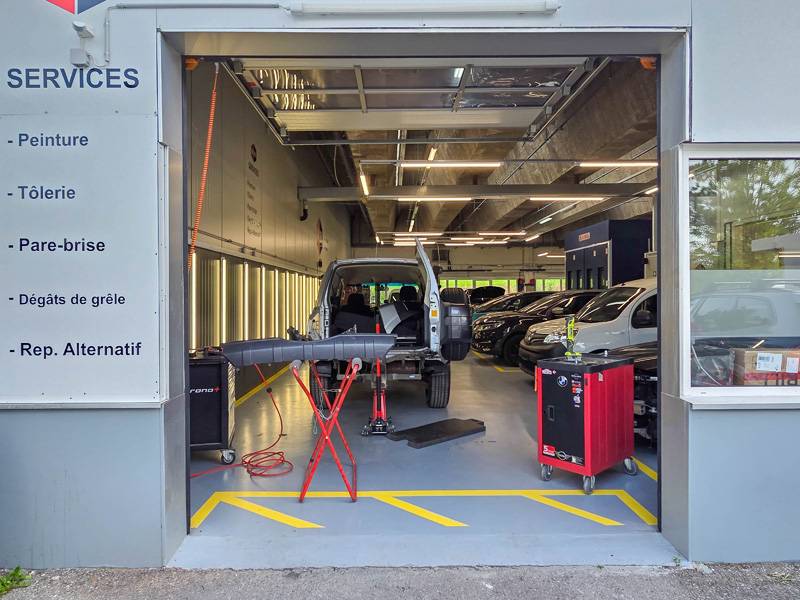Breit offen und ohne Umwege: Die Einfahrt führt in die Carrosseriewerkstatt. Schon von draussen lässt sich erahnen, dass hier nicht nur parkiert, sondern gearbeitet wird.