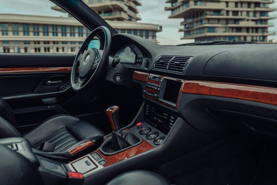 Holzdekor, Leder und ein vertrauter Schalthebel: Das BMW-Cockpit blieb weitgehend erhalten. Auch der W10 wird von Hand dirigiert – über das ursprüngliche Sechsganggetriebe.