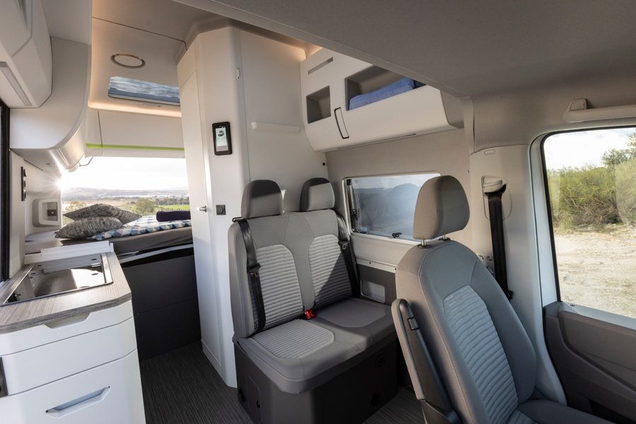 Une fois les sièges avant pivotés, la cabine fait partie de l’espace de vie. Elle offre ainsi des places supplémentaires pour une pause ou une soirée détendue. Photo : Volkswagen Nutzfahrzeuge (photo d’usine, Hanovre).